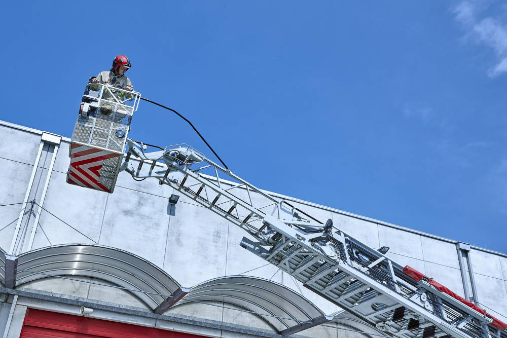 Un pompiere effettua un intervento con l'aiuto di una scala.