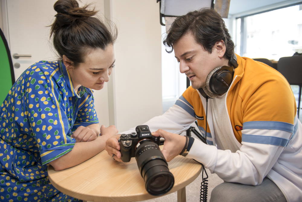 Un fotografo mostra a una cliente una fotografia sullo schermo della fotocamera.