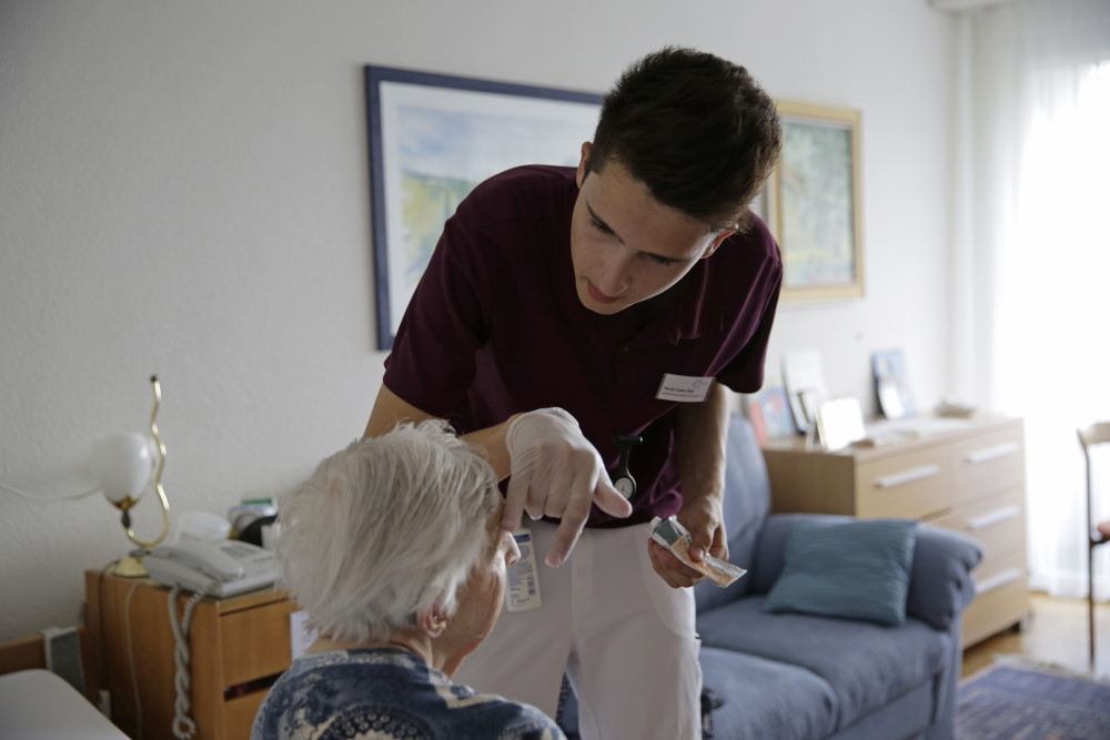 Un addetto alle cure si sta occupando dell'assistenza a un'anziana.