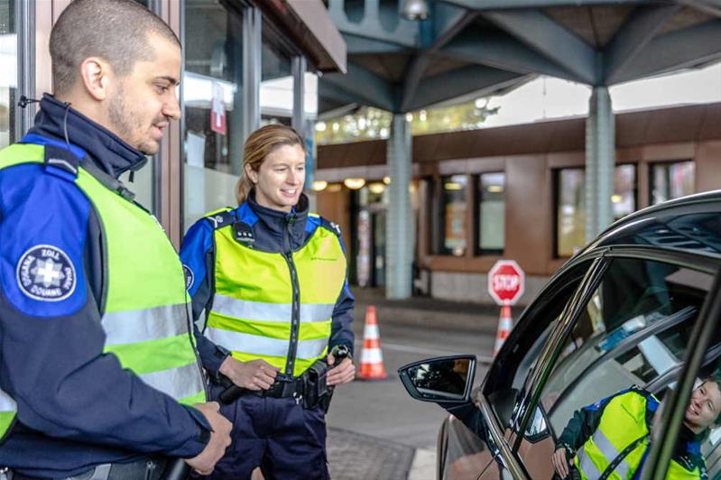 Dei doganieri discutono con un automobilista.