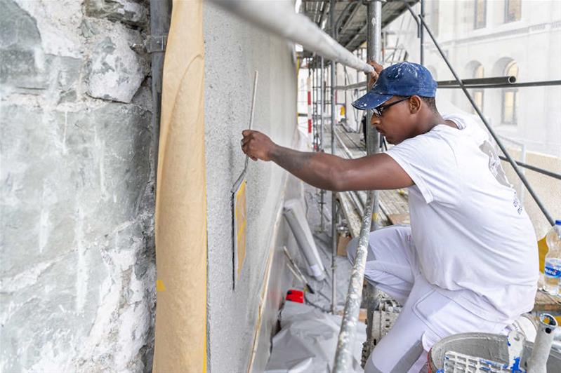 Un apprendista pittura una finestra.