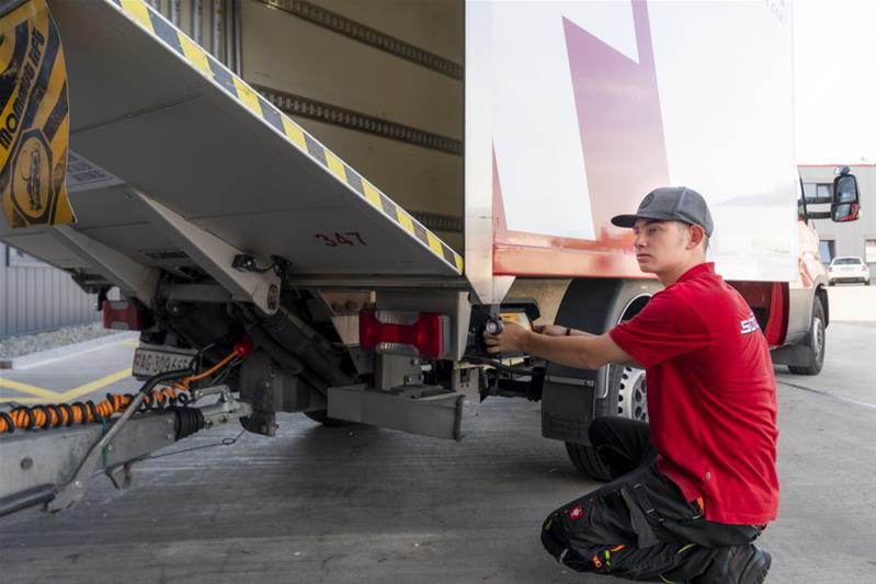 Un apprendista controlla il camion prima di partire.