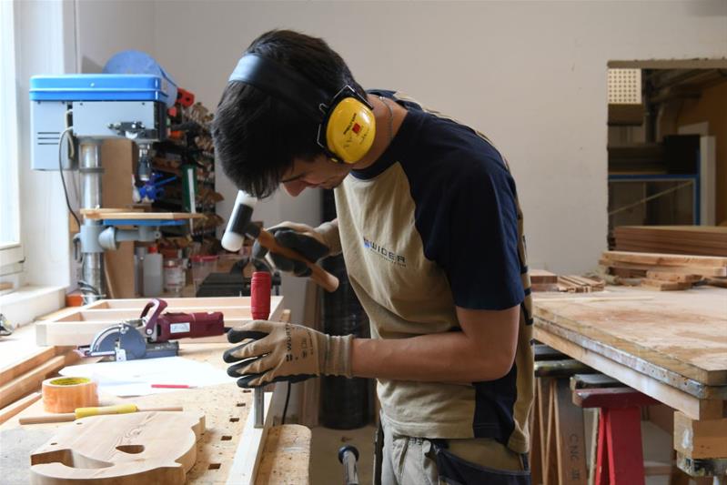 Un falegname sta lavorando su una tavola di legno.