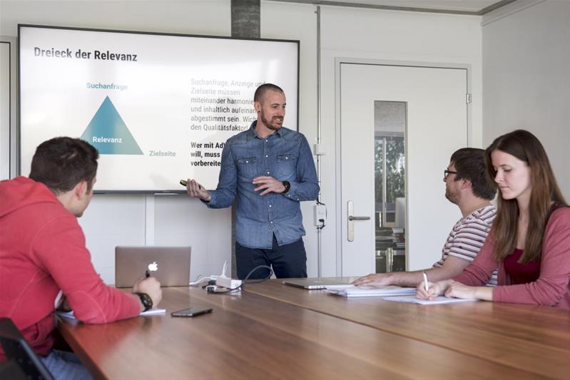 Un uomo presenta una riunione con l'aiuto di una presentazione PowerPoint.