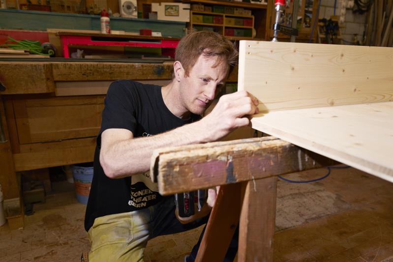 Dominik Lehmann Flury sta costruendo un cassone in legno.