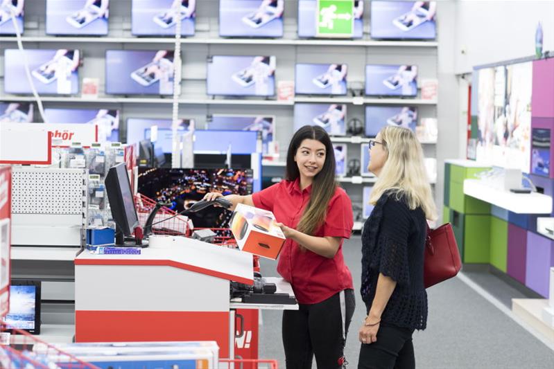 Una cassiera sta vendendo un prodotto a una cliente.