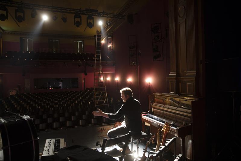 Professionista sul palcoscenico circondato da diversi strumenti musicali