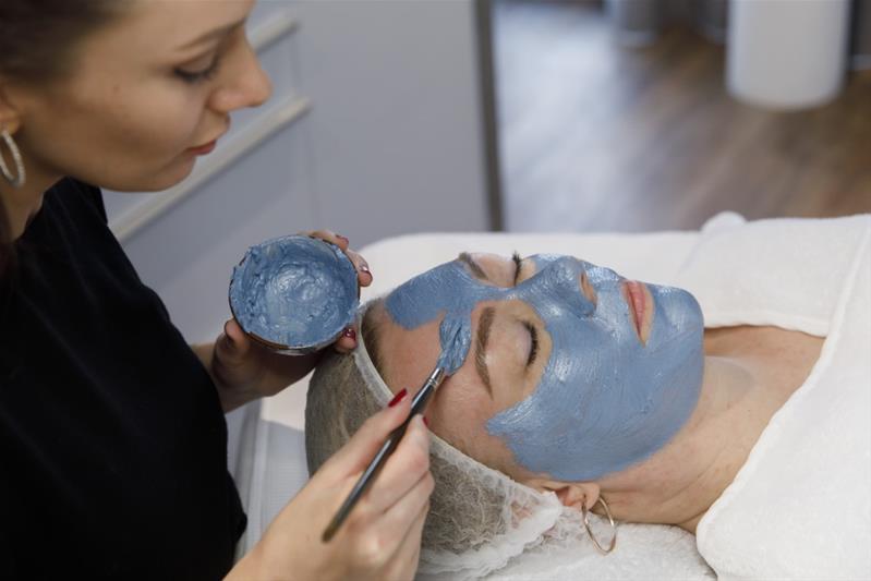 Debora Widmer applica una maschera sul viso di una cliente.