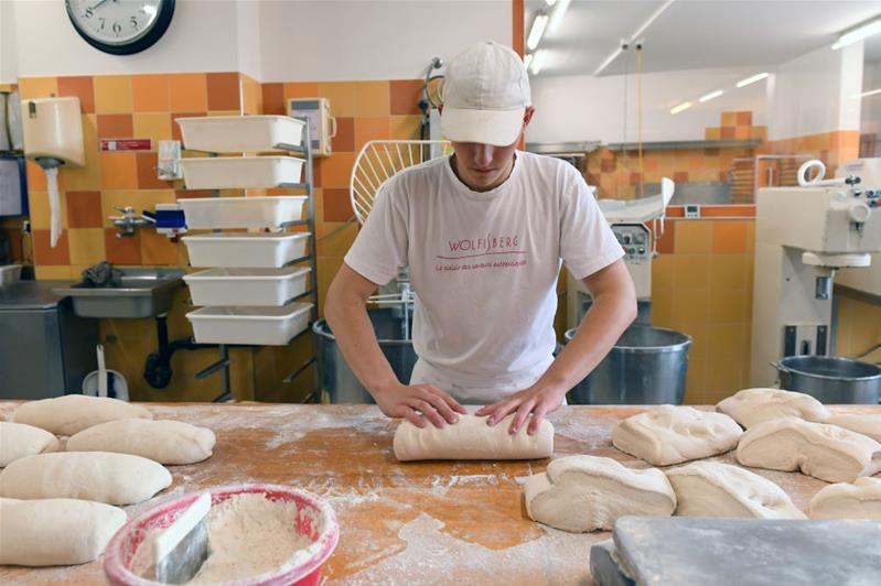 Un uomo lavora l'impasto per il pane.