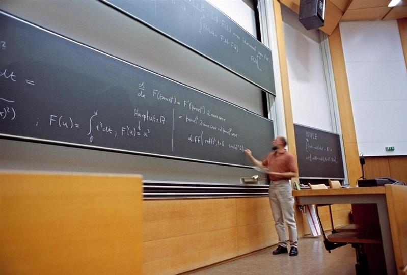 Un uomo scrive delle formule matematica alla lavagna