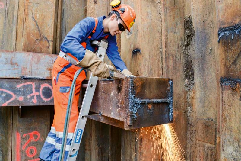 Un apprendista taglia e salda il metallo in un cantiere.