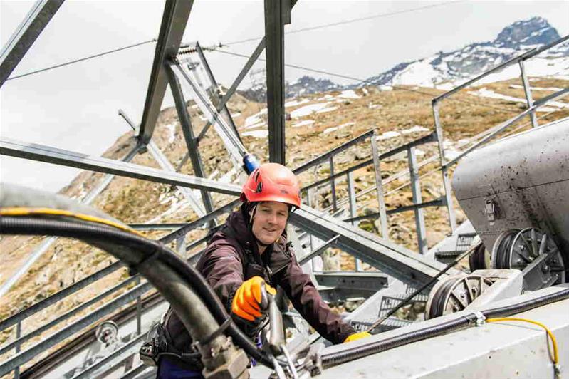 Un apprendista controlla un impianto di trasporto a fune.